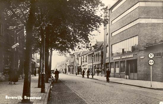 Breestraat
Dit is een ansichtkaart van de Breestraat gezien vanaf de Bloksteeg. De uitbreiding van de Beverwijkse Conservenfabriek was al gerealiseerd, de ansichtkaart is van rond 1940.
'De Bever' werd opgericht in 1896 en de fabriek werd gesloten in 1967 en kort hierna gesloopt. Het terrein heeft jaren braak gelegen alvorens het winkelcentrum de Beverhof gebouwd werd. Aansluitend aan de Conservenfabriek zien wij diverse winkels. Enkele namen? Juwelier Haak, manufacturenzaak van Lammers, Café Lunchroom de Zon, Café Royal, Slagerij van der Geest, de Joodse Synagoge, vrachtrijder Slings, de radiozaak van Minkema, De sigarenzaak van Max Lindner, jarenlang voorzitter van de Voetbalver. de Kennemers en nog veel meer. Dit alles is dus verdwenen om plaats te maken voor het winkelcentrum de Beverhof.
Keywords: Breestraat bwijk beverhof