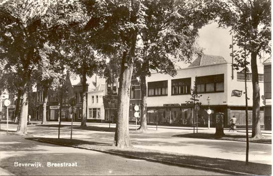 Breestraat
De Breestraat ter hoogte van de Nieuwstraat, het pand op de linkerzijde van de ansichtkaart is het pand van Stoutenbeek Modemodemagazijnen. Door de bomen kunnen wij nauwelijks de hiernaast staande panden herkennen. In de loop van zeker een eeuw hebben de diverse panden meermalen andere bestemmingen  gekregen. Wij willen daarom volstaan met een aantal namen van panden of de eigenaren  daarvan uit vroeger jaren min of meer op volgorde op te noemen. R.K.Land- en Tuinbouwbank, later Rabobank; Simon de Wit, later Kreymborg; Damesmode Spruit, Brood- en Banketbakkerij van E. ter Hoeve; Dagblad Kennemerland; Slagerij Hooy; Radio City en dan hebben wij de meeste panden wel genoemd maar zijn niet volledig geweest.
Keywords: bwijk Breestraat