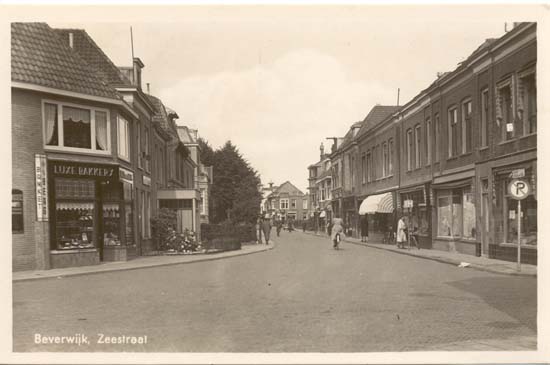 Zeestraat
De ansichtkaarten van de Zeestraat zijn talloos. Zij zijn ook van heel veel verschillende plaatsen. Deze kaart is van de hoek van de Zeestraat met de Koningstraat en dateert zeker van na 1945. De bakkerij is inmiddels fotozaak geworden, de waranda daarna is verdwenen, daar heeft Ab Geldermans nu zijn zaak, voor het overige zijn er eigenlijk geen zichtbare wijzigingen Er is nog weinig of geen verkeer, dat is nu wel anders.
Keywords: zeestraat