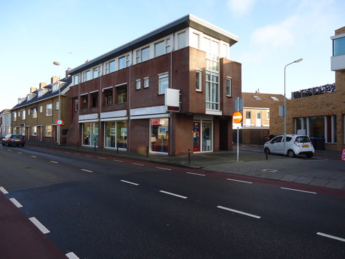 Alkmaarseweg 13 hoek Munnikenweg 27 januari 2015
Het oude pand wat hier heeft gestaan is tot 1980 bewoond geweest door polier Jan Jongejans. In 1956 kwam de familie Jongejans in dit pand wonen. Er moest veel aan verbouwd worden zoals de keuken en de poelierszaak met slachthok waar hij zelf slachtte. Het pandje op de hoek Alkmaarseweg/Munnikenweg werd op woensdag 22 april 1986 gesloopt. Ook de aan bepalende opslag ruimte ging onder de slopershamer. Beide panden moesten plaats maken voor verbreding van de Munnikenweg alsmede voor een stukje plantsoen dat hier zou worden aangelegd. Het pandje, dat eigendom was van de gemeente maar bewoond werd door mevrouw Tolman en haar zoon die na de poelier hier kwam wonen, werd begin 1986 geramd door een uit de bocht gevlogen auto. Daarbij werd een complete muur van de slaapkamer omver gereden. Niemand raakte gewond. Ook op de foto ziet u uiterst links nog de kraanbaan van steenhouwerij Groot. Deze steenhouwerij vestigde zich in 1919 aan de Munnikenweg. In 1991 verhuisde dit bedrijf om ruimte te maken voor nieuwbouw. De rechter foto laat de huidige situatie zien. Op de plaats waar eens de kippenboer heeft gewoond staat nu een appartementencomplex met kantoren op de begane grond. De steenhouwerij heeft plaats gemaakt voor een nieuw pand van het SIG. Het pand heeft de naam gekregen “Steenhouwerij” met de originele marmer gevelsteen.  De SIG is een relatief kleinschalige, professionele organisatie voor mensen met een verstandelijke beperking en/of stoornis uit het autistisch spectrum in Midden- en Zuid-Kennemerland.                

Foto’s : Prentenkabinet van der Linden/Co Backer
Tekst: Co Backer
Keywords: Bwijk Alkmaarseweg