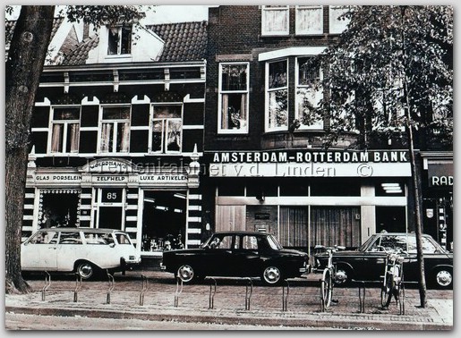 Breestraat
De Breestraat ter hoogte van nummer 70. Op de linker foto de toenmalige Amsterdam-Rotterdam Bank en nog een klein stukje zichtbaar van Radio City. Duidelijker is het pand van Woerdman, waar o.a. glaswerk, porselein en andere luxe artikelen werden verkocht, te zien. In de loop van zeker een eeuw hebben de diverse panden meermalen andere bestemmingen gekregen onder anderen was Vleeschhouwerij Klaas van Leeuwen hier gevestigd. De in de loop van 1980 geopende AMRO-bank kon er komen nadat de panden werden gesloopt. Ook deze bank heeft ’n nieuwe naam gekregen ABN AMRO-bank zoals de rechter foto weergeeft.   

Bron: Boek “Dit was Beverwijk”, auteurs: J.M. Van der Linden/ W. A. Spruit                 
Bewerking: Co Backer
                                                             
Keywords: bwijk breestraat