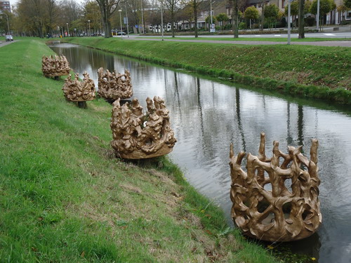 Kunst Meerestein
Kunstenaar Regula Maria Müller kreeg van de gemeente Beverwijk de opdracht voor een kunstobject in de wijk Meerestein. Haar werk werd gekozen uit een aantal schetsen, gemaakt door verschillende kunstenaars, die uit de selectie door de Adviescommissie Kunstzinnige Aankleding Beverwijk zijn geselecteerd. Met haar kunstobject verwijst de kunstenaar naar het oude landschap, slot Meerestein en de nieuwe geschiedenis, woningbouw voor werknemers van staalgigant Hoogovens IJmuiden. Haar beelden doen denken aan schelpen, waterspuwers of spatten gestold staal. In de wijk zijn veel verschillende gebouwen te zien, van langwerpige flats en parktorens tot vrije kavels. Daarom heeft Müller ervoor gekozen om meerdere objecten te plaatsen, verspreid over de hele wijk, als een handtekening die overal is terug te vinden. Het idee voor de objecten is afgeleid van de waterspuwers die vroeger bij kastelen het overtollige water van het dak uitspuwden.  vormen contrasteren mooi met de strakke bouwvormen en de kleur verhoudt zich goed tot die van de bebouwing. De vormen zijn vrij geboetseerde interpretaties gemaakt van zelfhardende synthetische klei, afgewerkt in een glimmende koperkleurige lak. Het betreft vijf grotere sculpturen rond de oever van de singel bij de entree van de wijk en ongeveer veertig kleine objecten aan lantaarnpalen verspreid in de wijk langs fietspaden en wandelroutes.

Bron: Woon op Maat Nieuwsbrief najaar 2009 nummer 3
Foto’s en bewerking: Co Backer
Keywords: bwijk Openbare Kunstwerken