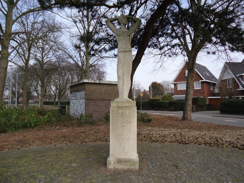 Monument Westerhoutplein
Rank van vorm en licht van kleur, zo staat het beeld van Gerrit Bolhuis erbij. Zorgeloos en vrij, na de benauwenis van de voorbije oorlogsjaren. De handen waren geboeid, maar de koorden zijn nu doorgesneden. In de tijd dat het hier werd geplaatst, vier jaar na het beëindiging van de Tweede Wereldoorlog, moet het beeld wit fris zijn geweest. Als de hoop op betere tijden. De putjes in het materiaal zijn niet oorspronkelijk: het zandsteen is door de jaren heen behoorlijk aangetast. De zure regen vormt een ware plaag voor beelden in de openlucht. Het beeld was een gift van de Beverwijkse inwoners aan het gemeentebestuur ter nagedachtenis van gesneuvelde militairen, omgekomen burgers, vermoorde verzetlieden en de slachtoffers van de concentratiekampen. Op 4 mei 1949 werd het beeld onthuld en nog steeds is dit de plek waar Beverwijk ieder jaar zijn doden van de laatste oorlog herdenkt. Kunstenaar Gerrit Bolhuis werkte aan het begin van zijn loopbaan in de traditie van Joop Toorop, schilder en beeldhouwer die van 1870 tot 1900 in Nederland werkte. Het beeld heeft dan ook iets ‘Jugenstilachtigs’, een favoriete kunstvorm rond de eeuwwisseling. Dat Bolhuis zich door deze periode liet inspireren, kun je onder meer aflezen aan de gestileerde vormen van het beeld.    

Bron: Blik op Beeld, Tekstbureau Zonneveld & Thöne i.o.v. gemeente Beverwijk, 2006.
Foto en bewerking: Co Backer
Keywords: bwijk Monumenten