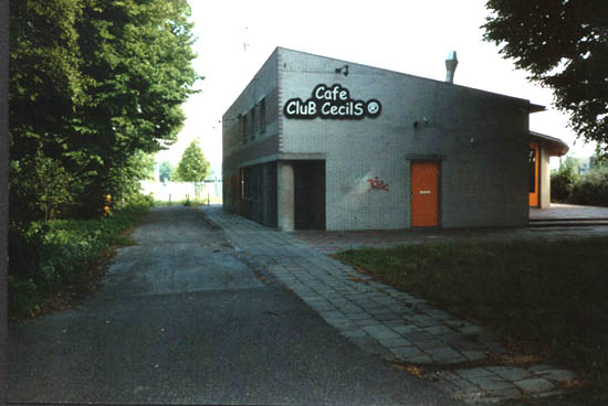 Adrichemlaan v.a. Hoflanderweg
Club Cecils aan de overkant van Sporthal de Walvis. Het gebouw werd neergezet in de jaren tachtig ter vervanging van het oude Labyrinth en heette in eerste instantie dan ook Het Labyrinth. Later veranderde het beheer van het pand en werd Podiumcafe Het Vervolg erin gehuisvest. Eind jaren negentig kwam er dan Club Cecils. Op het terrein links van het pand stond tot halverwege de jaren tachtig de St. Bernhardschool, ook wel Dierenschooltje genoemd, een reeks houten gebouwen dat bij leegstand herhaalde malen in brand werd gestoken door baldadige jeugd voor het gesloopt kon worden. Achter Cecils de voetbalvelden van DEM.
Keywords: Hoflanderweg Adrichemlaan