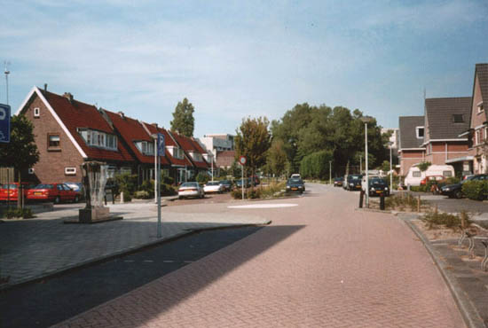 Hoflanderweg
Een stuk dichter bij de Laan der Nederlanden vinden we dit straatbeeld. Rechts staat nieuwbouw. De huizen links staan er al veel langer. Onder het groen van de bomen rechts op de foto staat nog altijd de hoeve Oosterwijk. De schaduw op de voorgrond is van een kleine flat dat het Overbospark overziet.
Keywords: Hoflanderweg