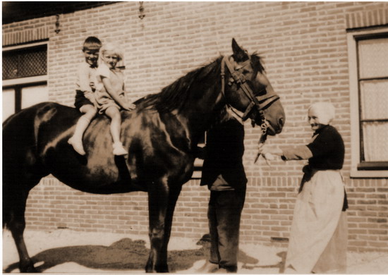 Personen uit het dorp
Mw. De Boer, 2 kleinkinderen op het paard en daarachter, gedeeltelijk zichtbaar,  Piet de Boer. 1935
Keywords: waz