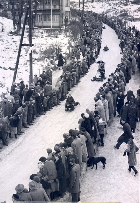 De Hoge kop, met de slee naar beneden
Wat een feest was dat als de Hoge kop dicht ging voor het sleeën.

1958 was het laatste jaar waarin dat nog kon, want daarna is het Hoge Duin er gekomen. De foto laat het gekostumeerd sleetje rijden zien, waar veel kijkers op af kwamen; het gehele dorp liep leeg.  De sleeën waren van hout en vaak zelfgemaakt.
Keywords: volksfeesten waz hoge kop